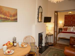 a living room with a table and a bedroom at Gamekeeper's Cottage in Staple