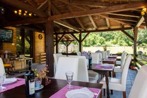 a restaurant with white chairs and tables and a wooden ceiling at B&B Villa Nena in Plitvica Selo
