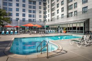 Una gran piscina con sillas y un edificio. en Chicago Marriott Suites Deerfield, en Deerfield
