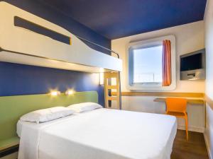 a bedroom with a white bed and a window at ibis budget Sertaozinho in Sertãozinho