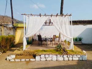 a patio with a table and a white canopy at The Fair Heavens Suite One bedroom self contained in Freetown