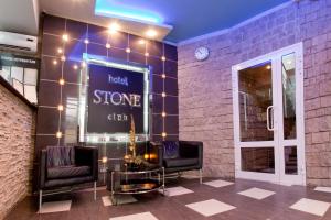 ヨシュカル・オラにあるHotel-Boutique Stoneのサロン(椅子2脚付)とホテルの石造りのクラブを読むサイン