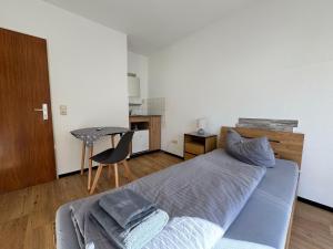 a bedroom with a bed and a table and a chair at Zur goldenen Krone Pension Stadtallendorf in Stadtallendorf