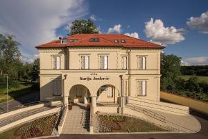 a large white building with a red roof at Hotel Kurija Janković in Lukač