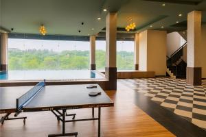 ジャイプールにある6BHK Villa with pool Near Jaipur Junctionの大きな窓の前に卓球台がある広い部屋