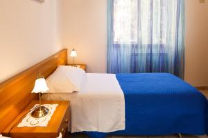 a bedroom with a blue and white bed and a table at Casa Nonna Netta in Sorrento