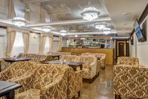 a restaurant with chairs and tables and a bar at Nairi Hotel in Volgograd