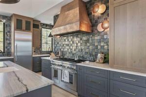 a kitchen with blue cabinets and a stove top oven at 11981 N Gemini Way SkyRidge 5BR Home with Hot Tub home in Keetley
