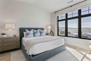a bedroom with a large bed with a large window at 11981 N Gemini Way SkyRidge 5BR Home with Hot Tub home in Keetley