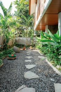 a garden with a walkway in front of a building at Ningmas Casita Residence Villa by Sidhi Experiences in Ubud