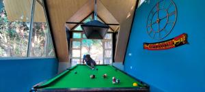 un bambino che gioca a biliardo in una sala giochi di Nomadsland by Cottage Club Inn a Nainital