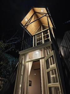 un edificio con una torre con finestre di notte di Nomadsland by Cottage Club Inn a Nainital