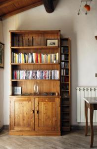 una estantería de madera llena de libros en una habitación en Casa Con Soppalco ad Ariccia, en Ariccia