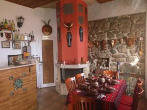 a dining room with a table and a stone fireplace at Centaur Family Hotel in Rila