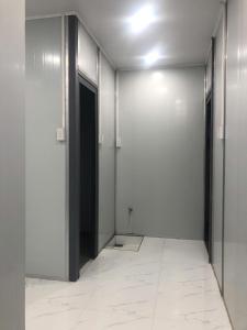 pasillo con puertas negras y suelo de baldosa blanca en Phan House, en Hà Tiên