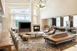 a lobby with a fireplace and tables and chairs at Residence Inn Rochester Henrietta in Rochester