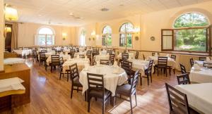 a dining room with white tables and chairs at Balneario de Manzanera El Paraíso in Manzanera