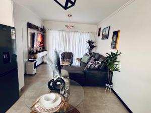 Chanty Serenity Apartment with Pool and Gym في Sandton: غرفة معيشة مع أريكة وطاولة زجاجية