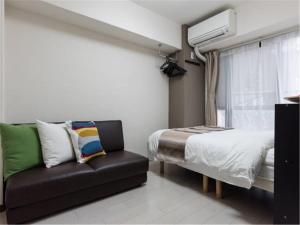 a small bedroom with a bed and a couch at House L in Shinjuku in Tokyo