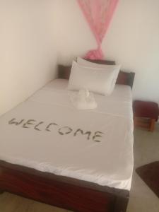 - un lit avec le mot de bienvenue écrit sur celui-ci dans l'établissement Rangiri Villa Sigiriya, à Dambulla