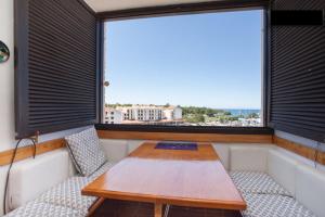 einen Tisch und Stühle in einem Zimmer mit Fenster in der Unterkunft Apartment Dubravka I in Poreč