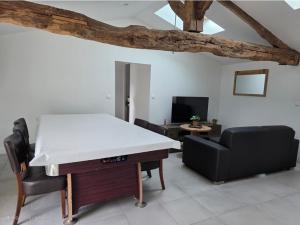 a living room with a table and a couch at Maisonnette familiale entre Nantes et Pornic in Brains