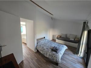 a bedroom with a bed and a couch in it at Maisonnette familiale entre Nantes et Pornic in Brains +2 photos