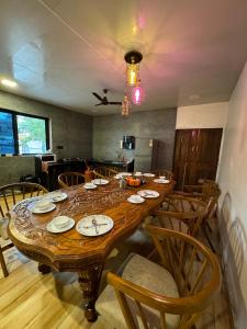 a large wooden table in a room with chairs at VG09 with huge Pool and bathtub in Lonavala