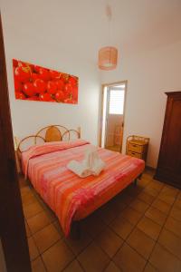 una camera con un letto e un dipinto di pomodori di SanvitoTour - Le Terrazze a San Vito lo Capo
