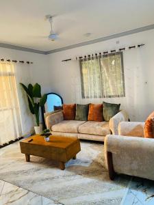 a living room with two couches and a coffee table at Casa Bellah Sunset in Watamu