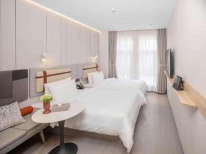 Postel nebo postele na pokoji v ubytování Home Inns Shanghai Liuzhou Road Everbright Exhibition Center Branch