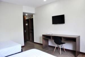 a room with a desk and a tv on a wall at S Hotel & Residences in Cebu City