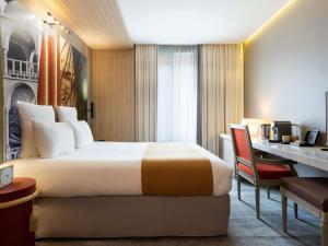 a hotel room with a bed and a desk at Mercure Paris Alesia in Paris