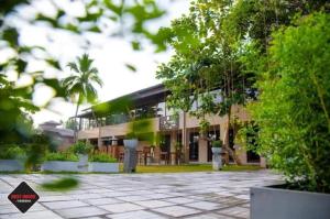 KesbewaにあるREST HOUSE KESBEWAの前に木がある建物
