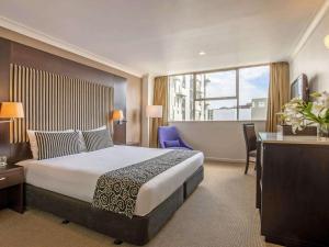 a hotel room with a large bed and a desk at Mercure Wellington Abel Tasman in Wellington