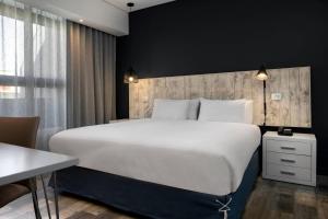 a bedroom with a large white bed and a desk at Protea Hotel Fire & Ice! by Marriott Durban Umhlanga Ridge in Durban