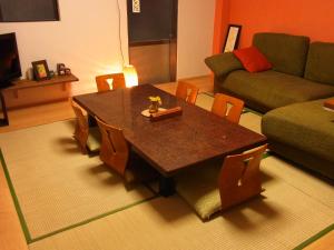 uma sala de estar com uma mesa e um sofá em Guesthouse Shirahama em Shirahama