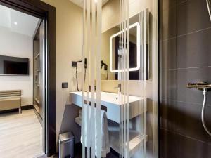 a bathroom with a white sink and a mirror at Novotel Madrid Center in Madrid +99 photos