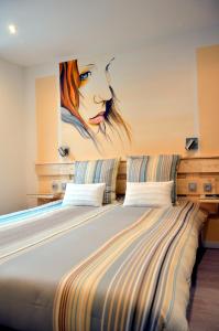 un grande letto con un dipinto di una donna di Gites Spa Strasbourg - Gite le 14 a Furdenheim