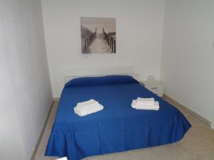 a bedroom with a blue bed and a bridge at Villa Bocca del Pozzo in Gagliano del Capo