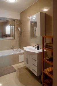 une salle de bain avec un lavabo, une douche et une baignoire dans l'établissement Core Luxembourg City - Bullseye, à Luxembourg