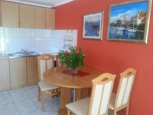 une cuisine avec une table en bois et un vase de fleurs. dans l'établissement Holiday Home Milenka, à Rogoznica