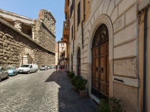 um beco com uma grande porta de madeira num edifício em Residenza Maritti ContemporarySuite em Roma