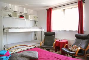 a bedroom with a bunk bed and two chairs at Logies Ternier - Het Victorhuis in Nieuwpoort