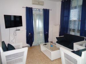 a living room with a couch and a tv at Villa Bocca del Pozzo in Gagliano del Capo
