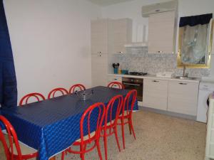 a kitchen with a blue table and red chairs at Villa Bocca del Pozzo in Gagliano del Capo +46 photos