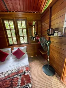 エッラにあるWonder Tree Lodgeのベッドルーム1室(赤い枕とファン付きのベッド1台付)