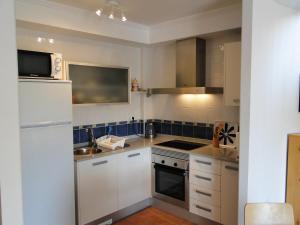 a kitchen with white cabinets and a sink and a microwave at Residencial Almadraba E2 in Águilas