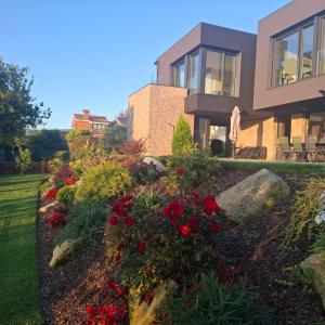 a house with a flower garden in front of it at Chalet de lujo con piscina cercano a la playa in Nigrán