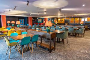 a cafeteria with tables and chairs in a room at Whispering Dunes - Silver Sands Holiday Park in Lossiemouth